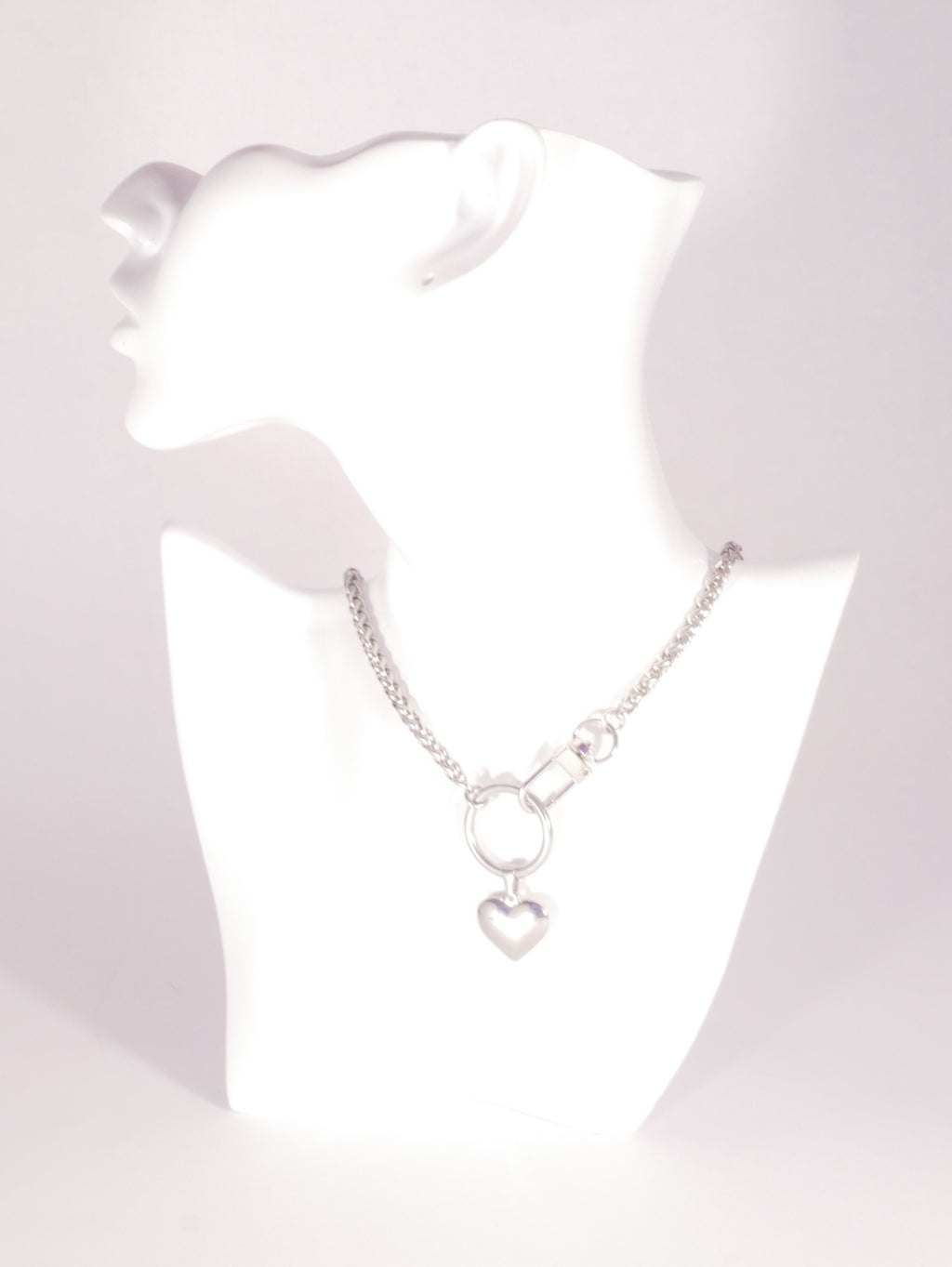 Silver necklace with heart pendants on a white mannequin bust.