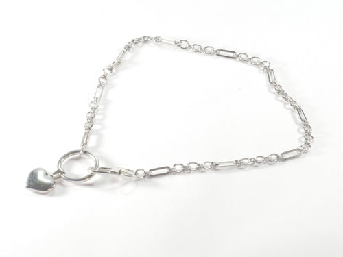 Silver bracelet with a heart charm on a white background