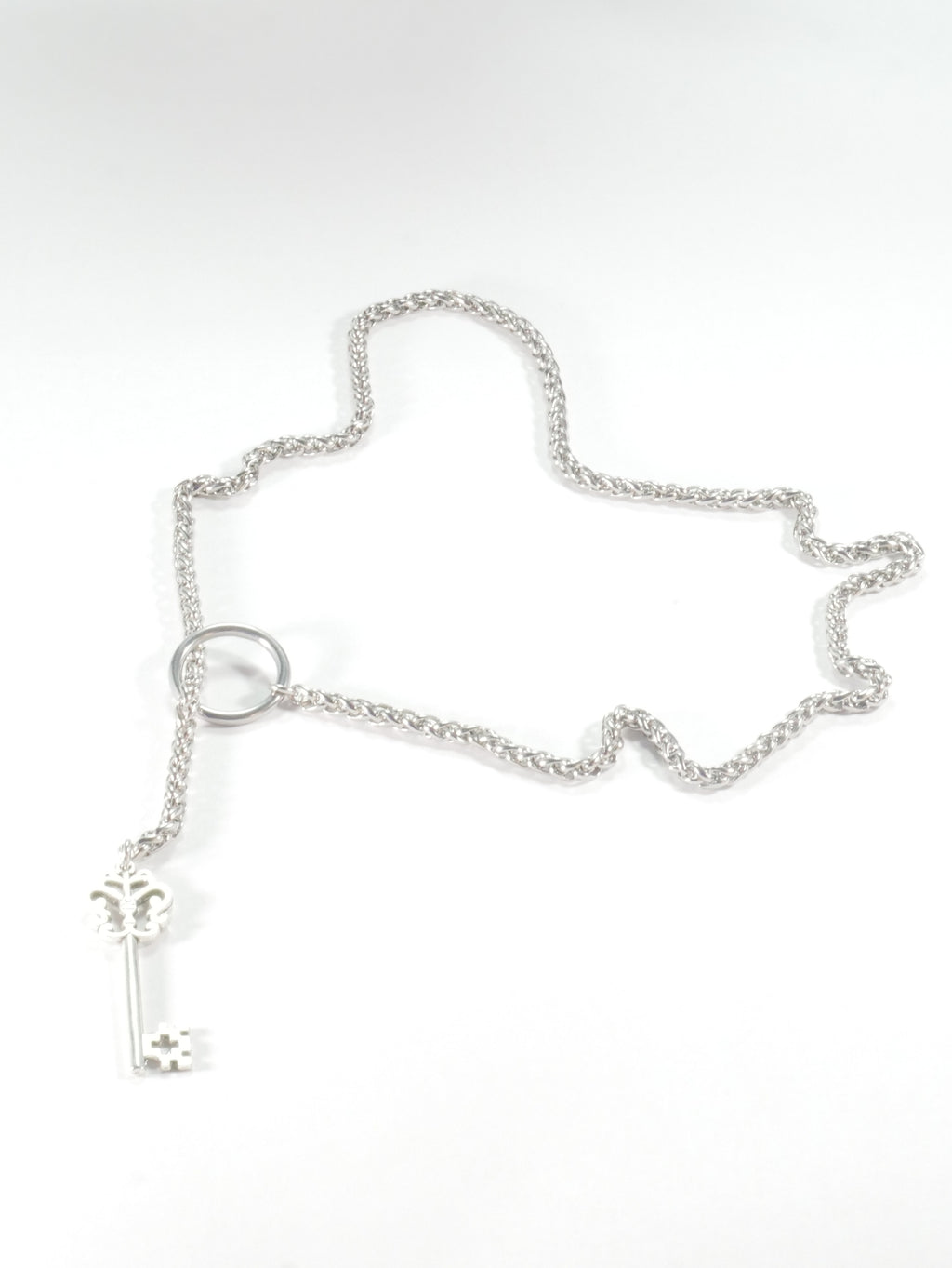 Silver chain bracelet with a key charm on a white background