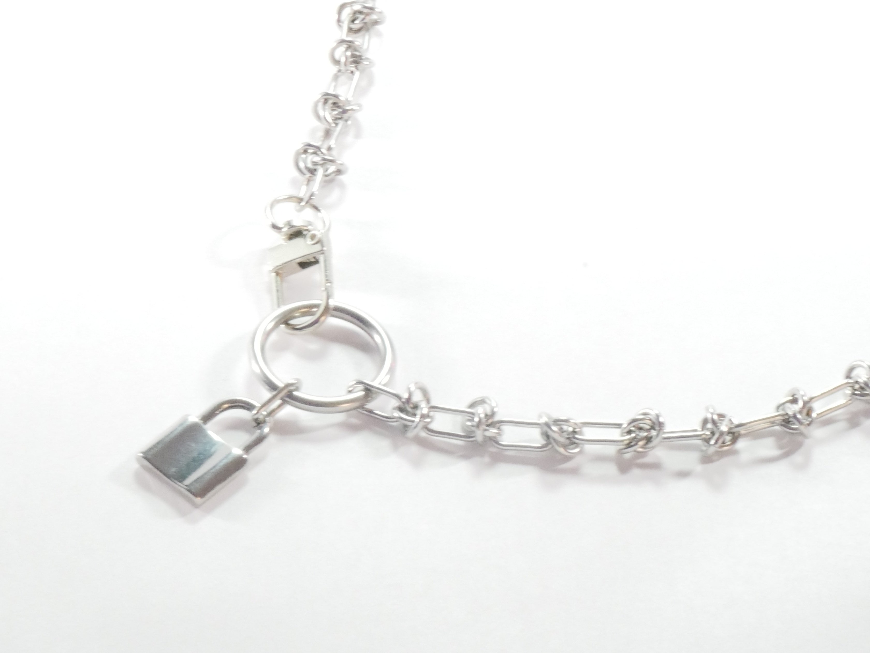 Silver chain bracelet with a lock charm on a white background