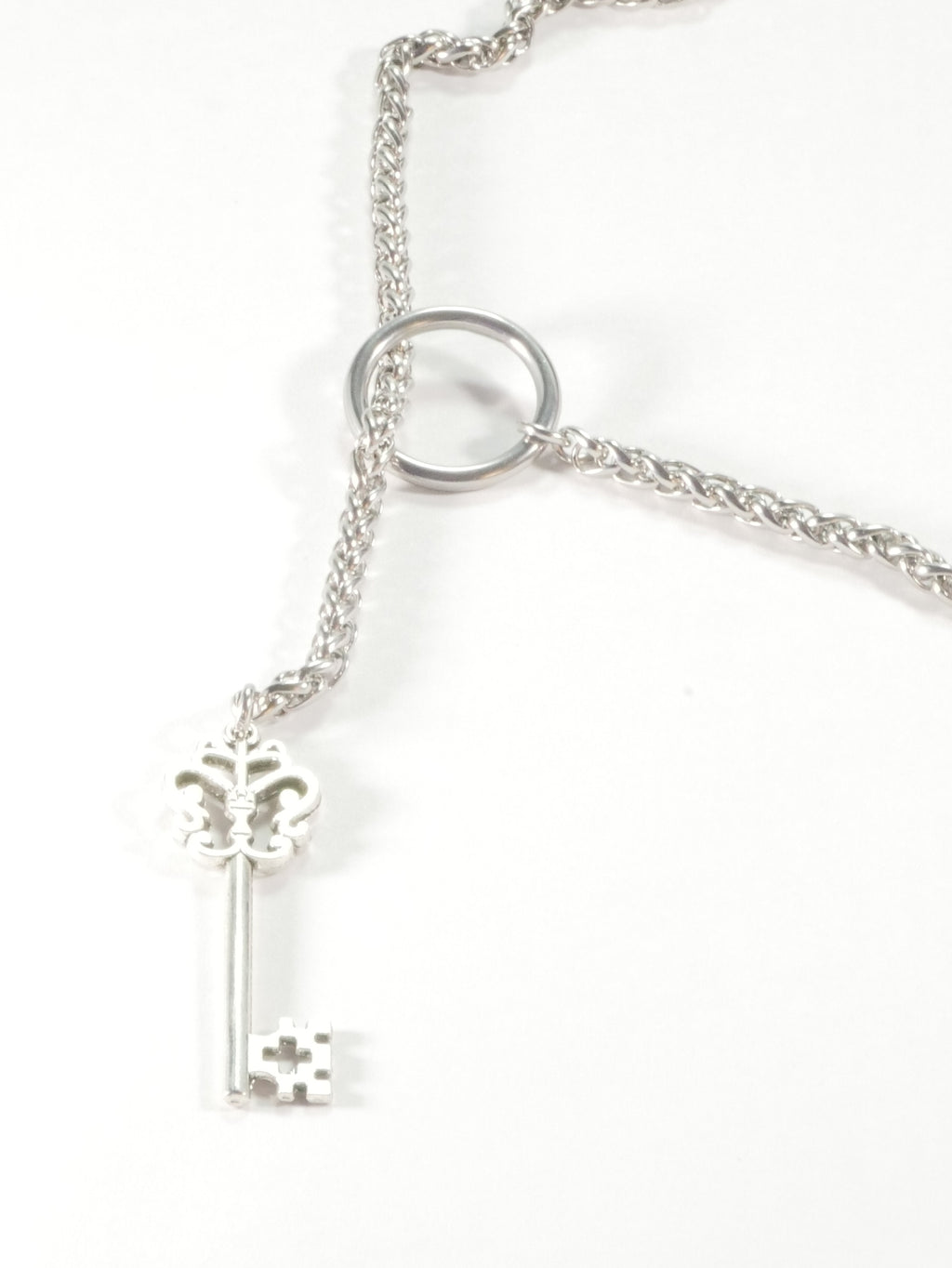 Silver key-shaped pendant on a chain against a white background