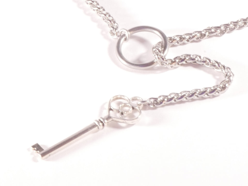 Silver key-shaped pendant on a chain against a white background
