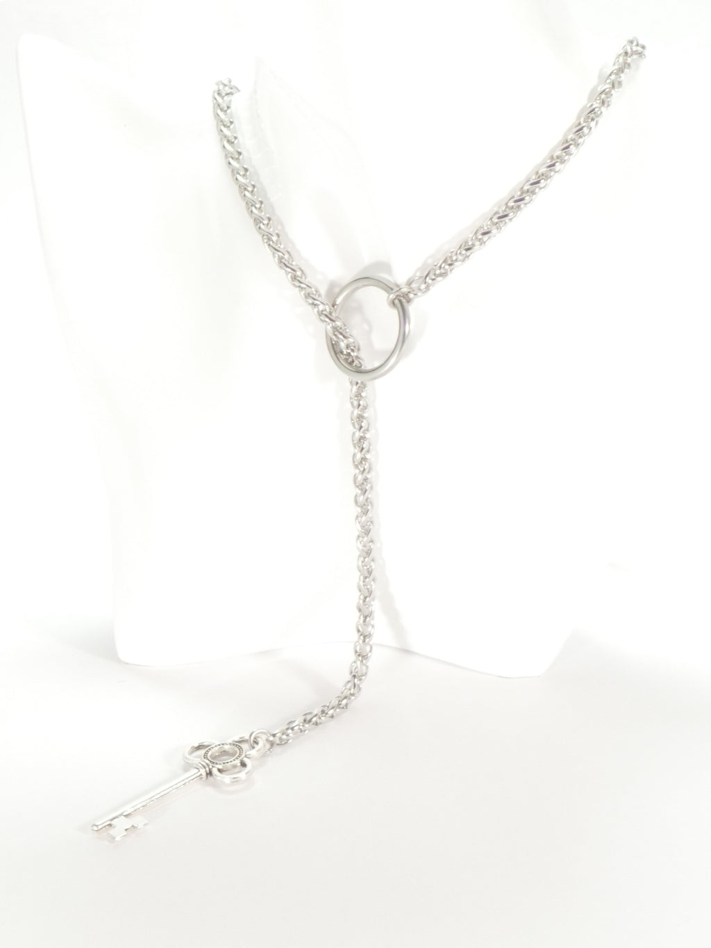 Silver necklace with a circular pendant on a white background