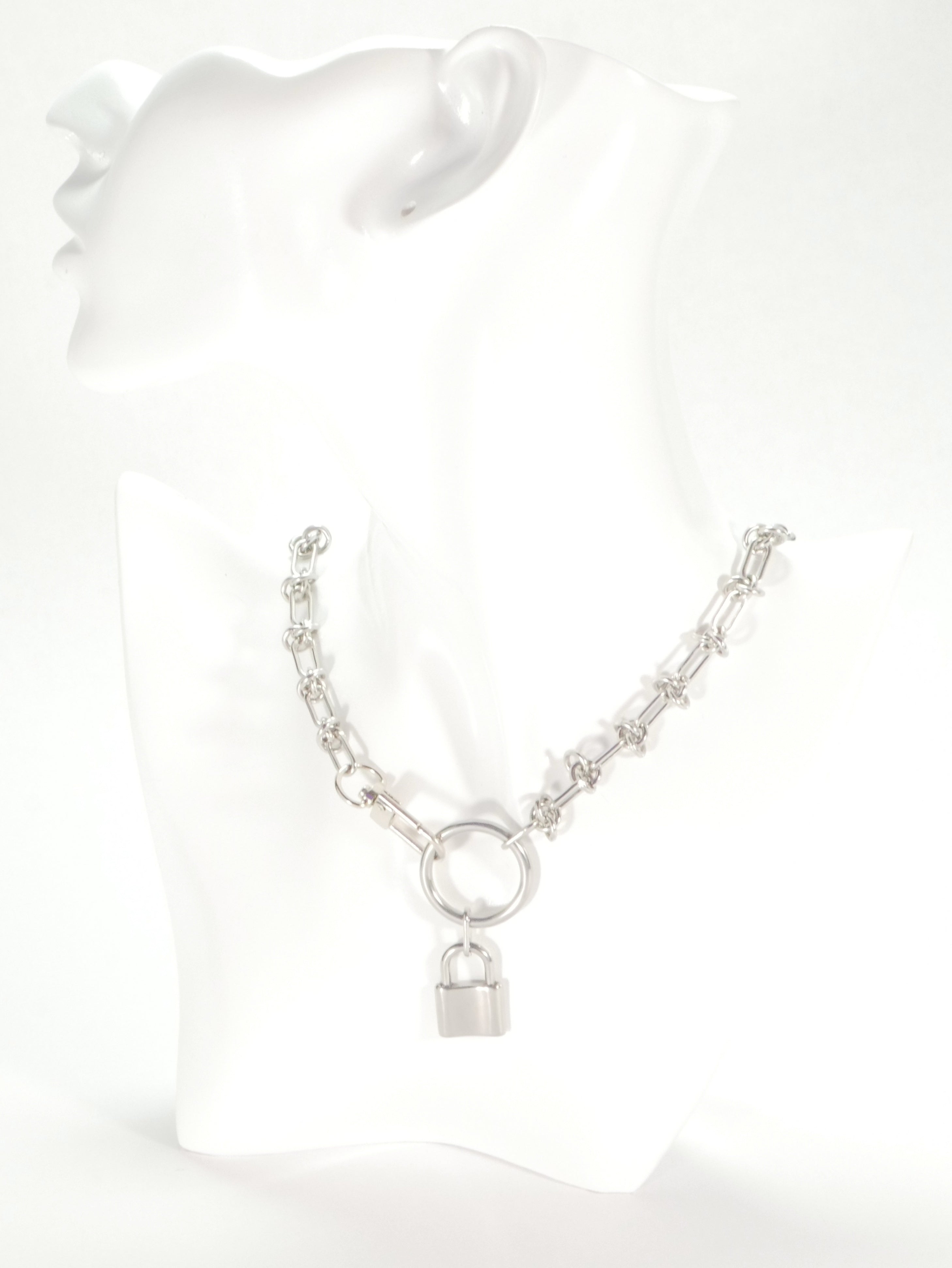 Silver necklace with a lock pendant on a white mannequin bust.