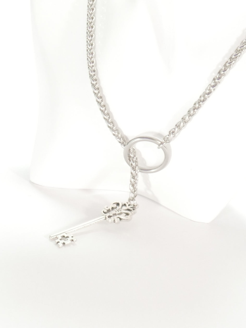 Silver necklace with a small pendant on a white background
