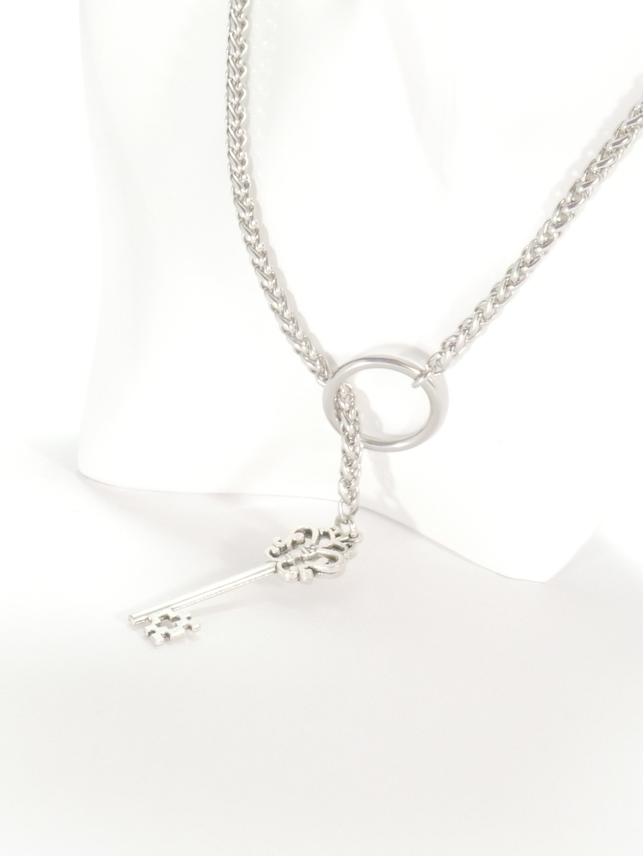 Silver necklace with a small pendant on a white background