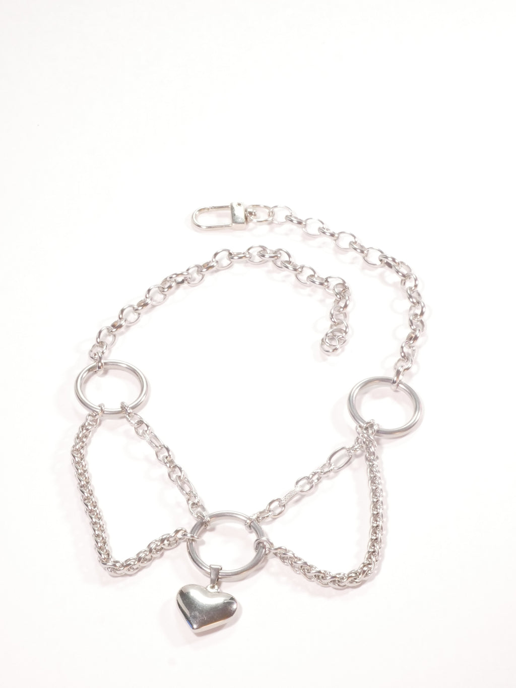 Silver necklace with heart charm on a white background