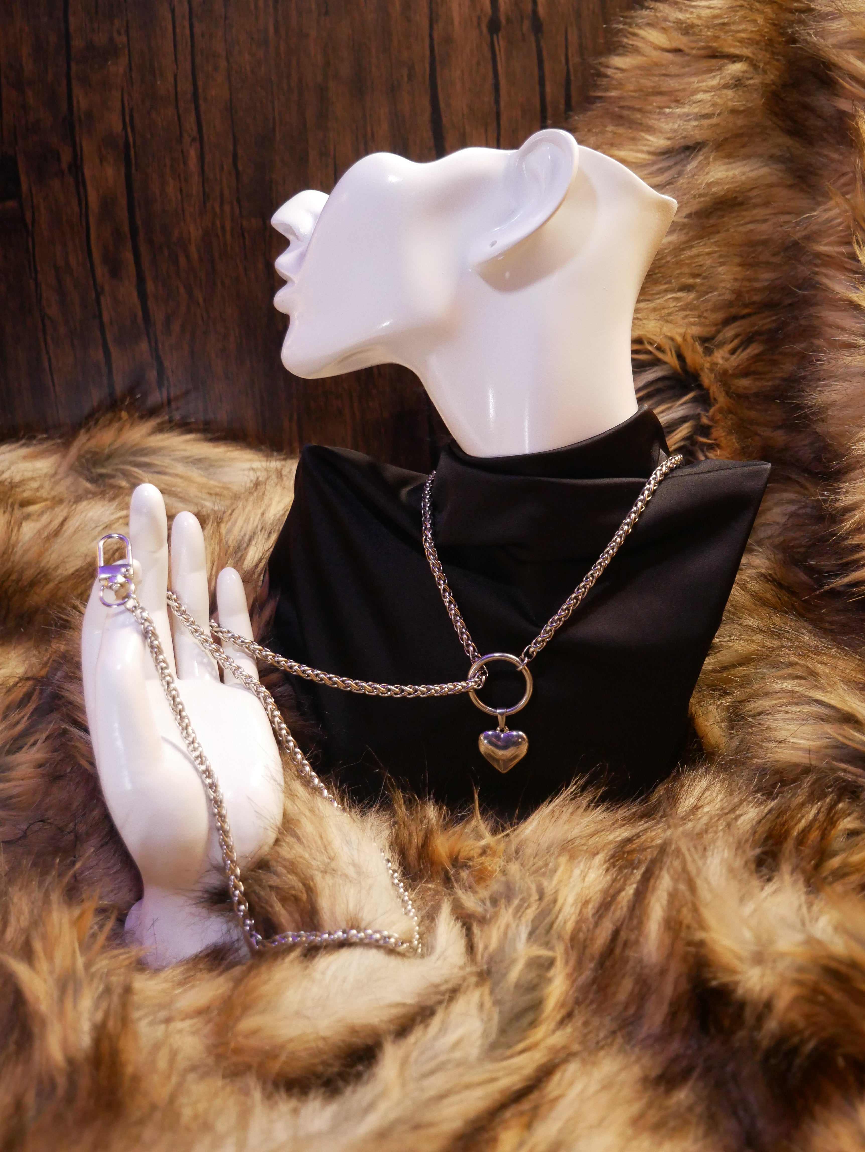 silver chain necklace on a mannequin wearing a black satin top sitting on a brown fur