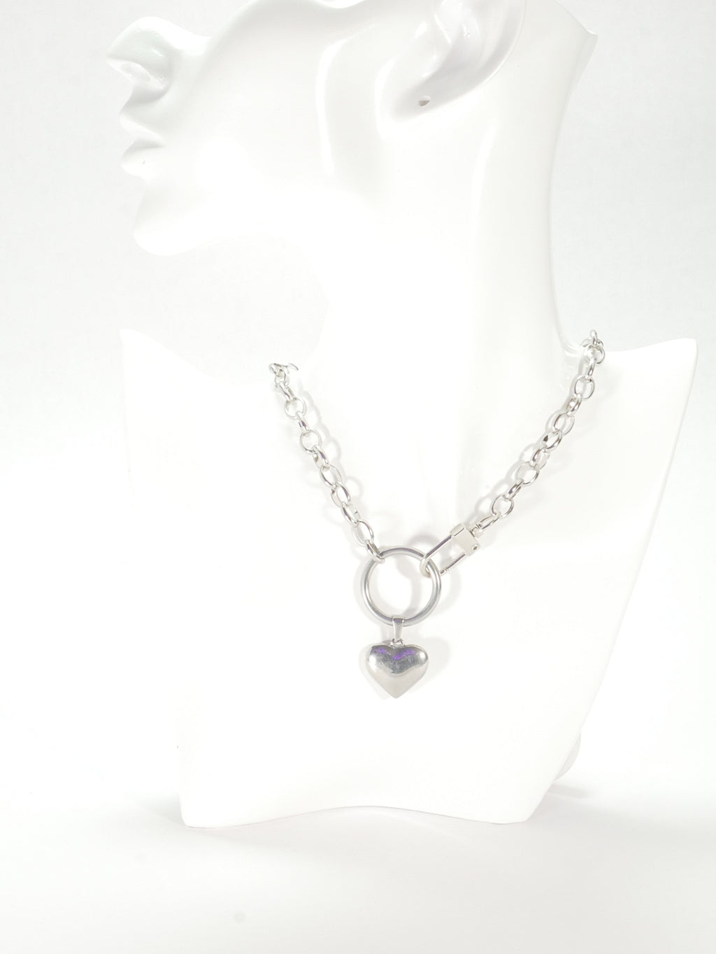 Silver necklace with a heart-shaped pendant on a white background