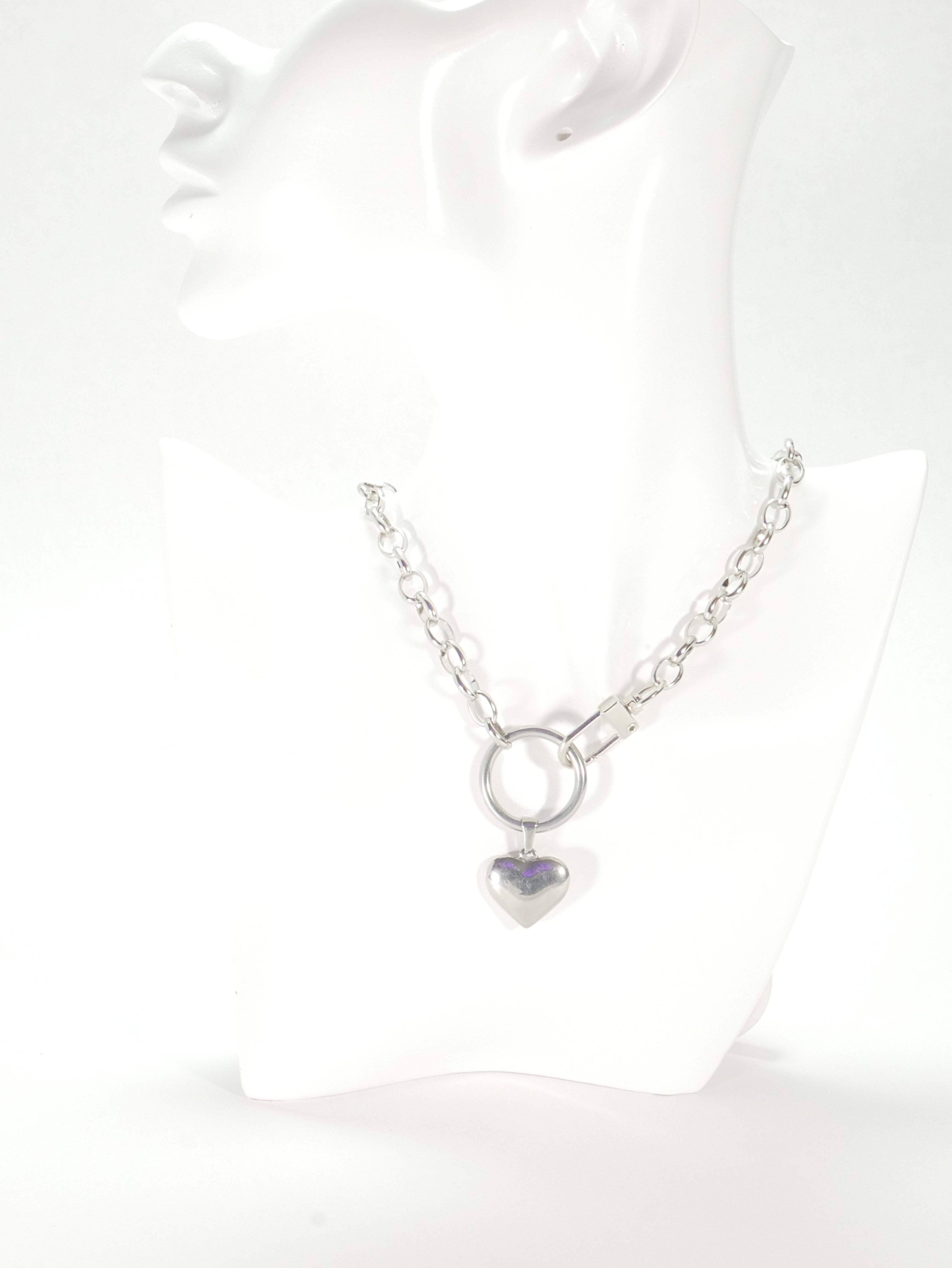 Silver necklace with a heart-shaped pendant on a white background