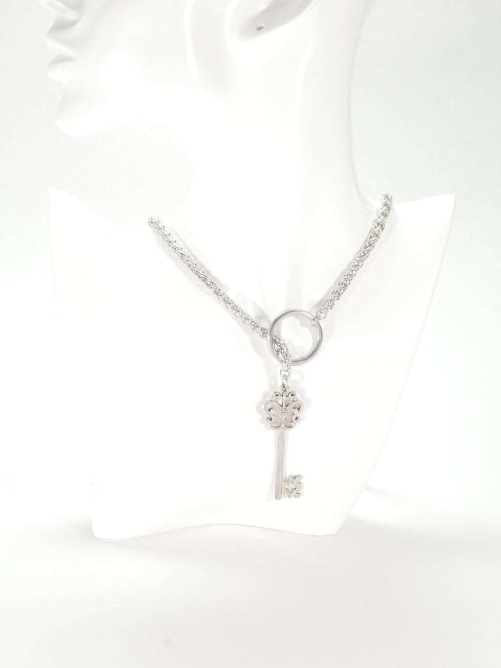 Silver bracelet with key charm on a white background