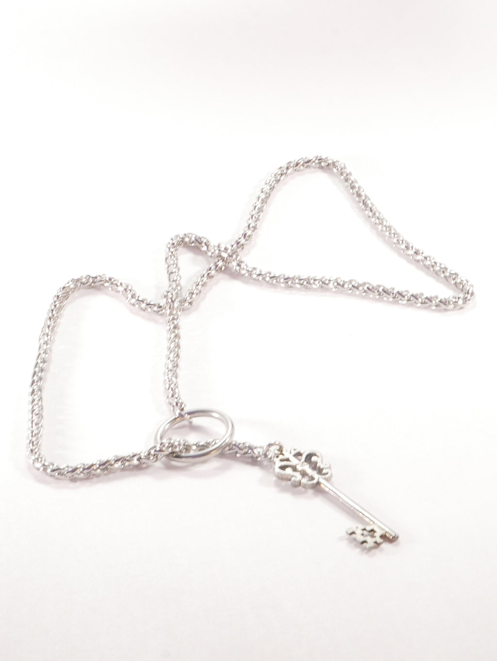 Silver bracelet with a key charm on a white background