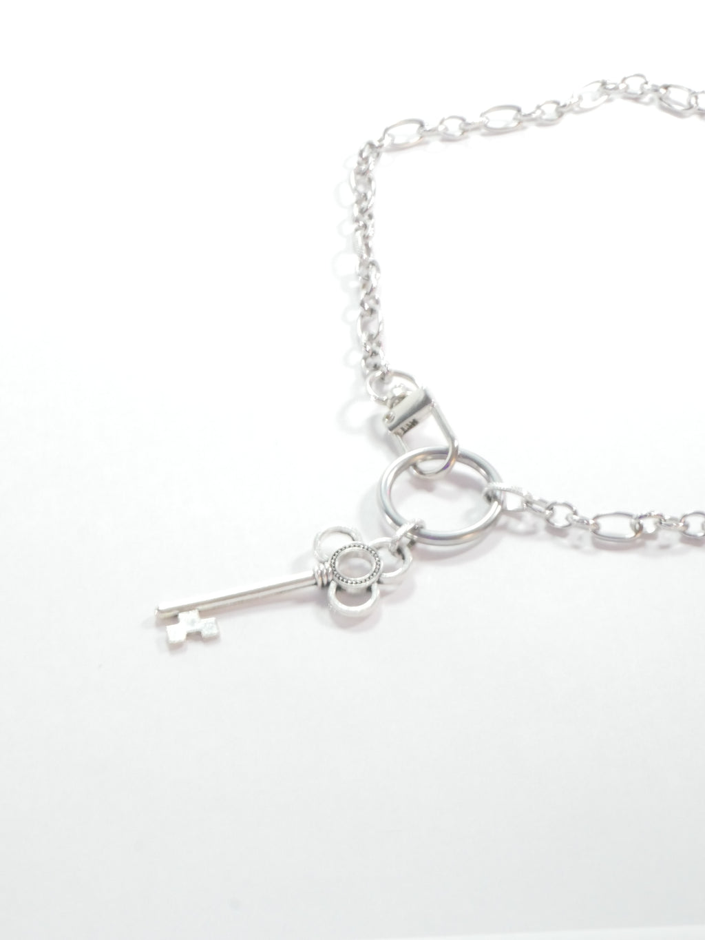 Silver key necklace on a white background