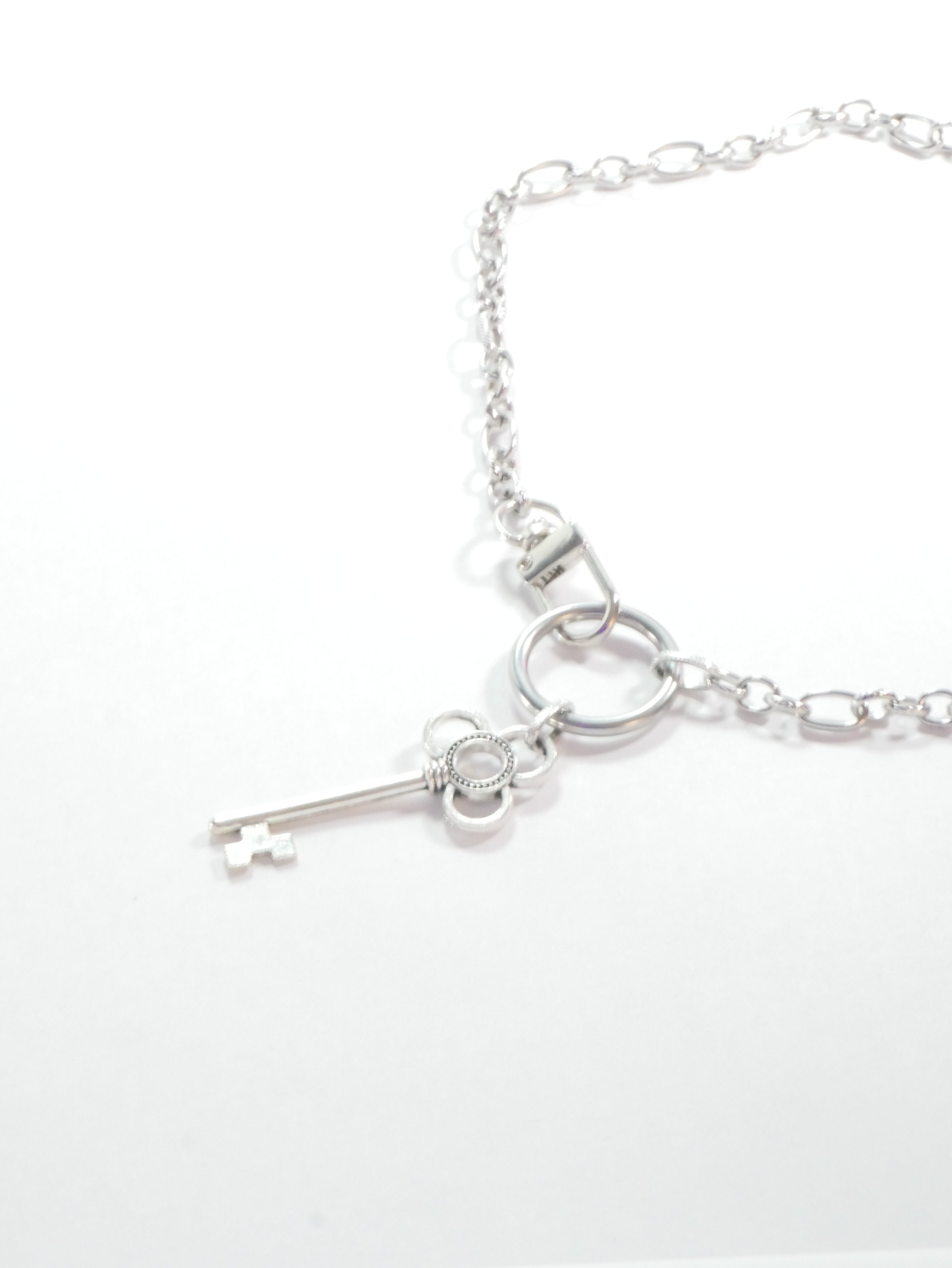 Silver key necklace on a white background