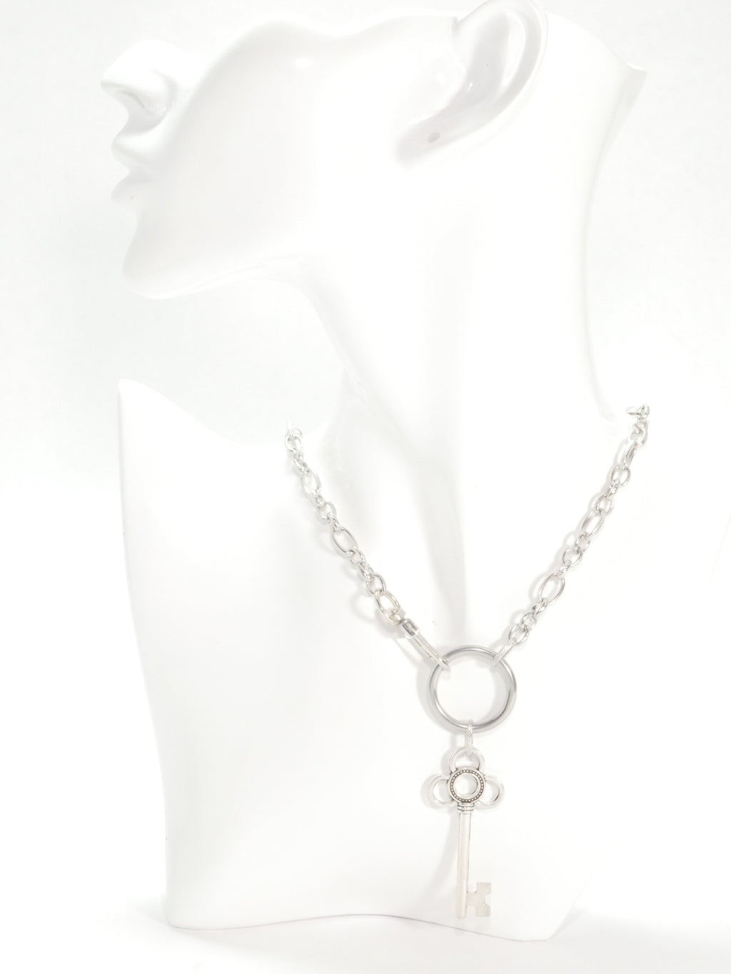 Silver necklace with a key pendant on a white background