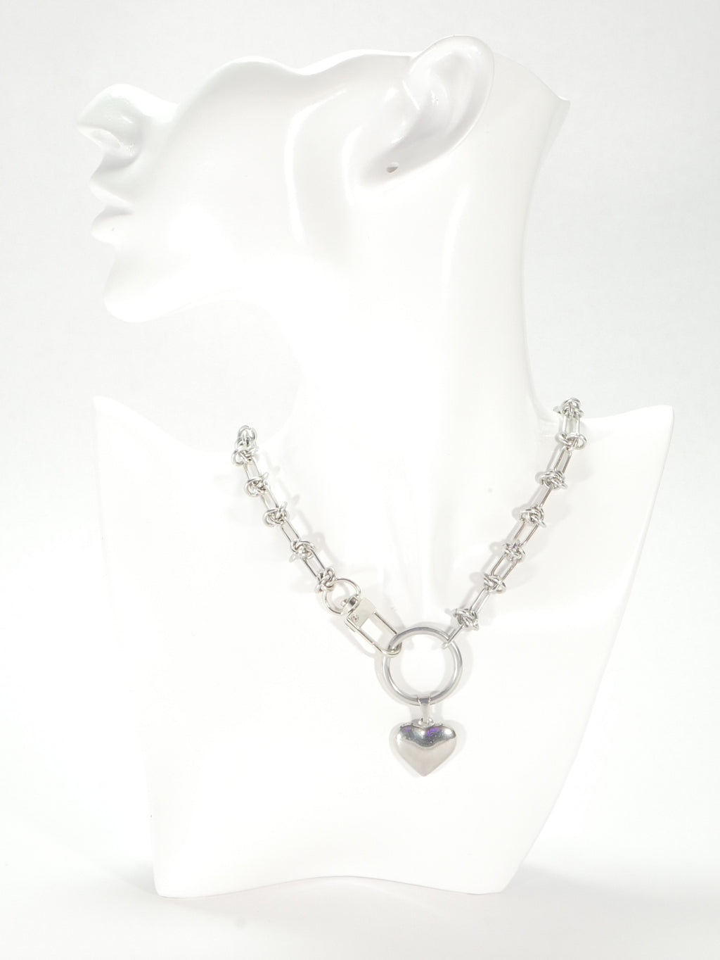 Silver necklace with a heart pendant on a white background