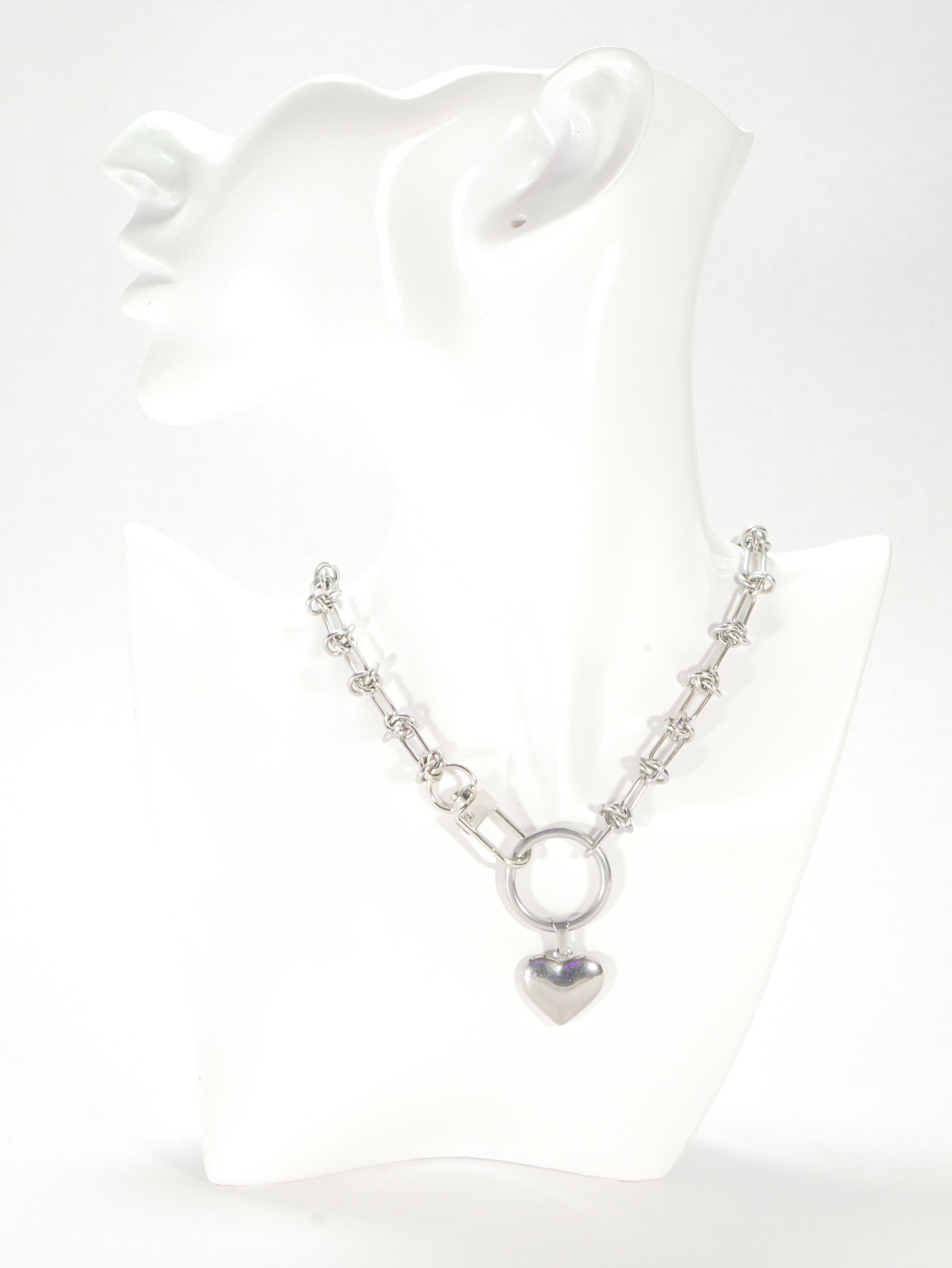 Silver necklace with a heart pendant on a white background