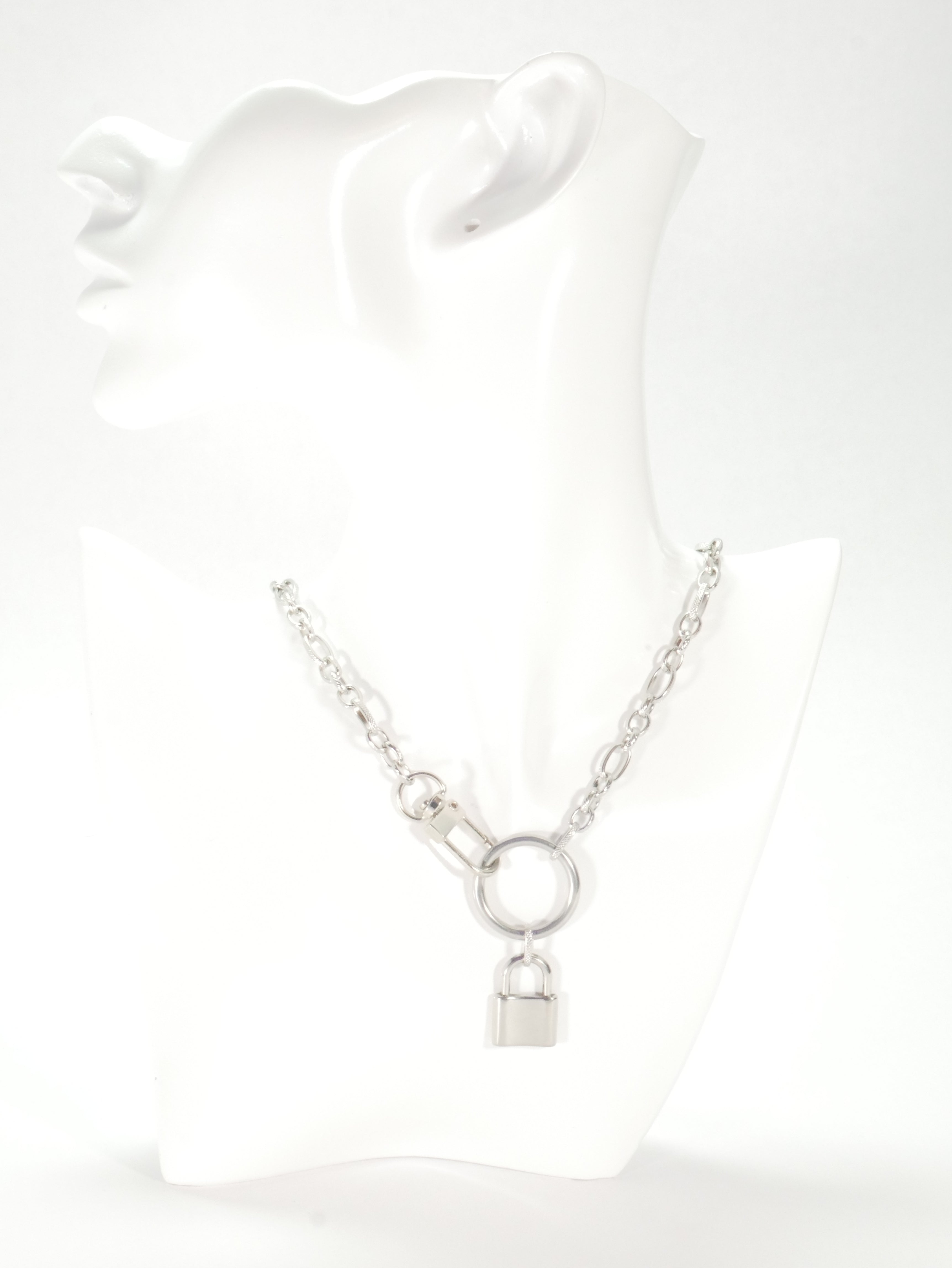 Silver bracelet on a white mannequin arm with a plain background