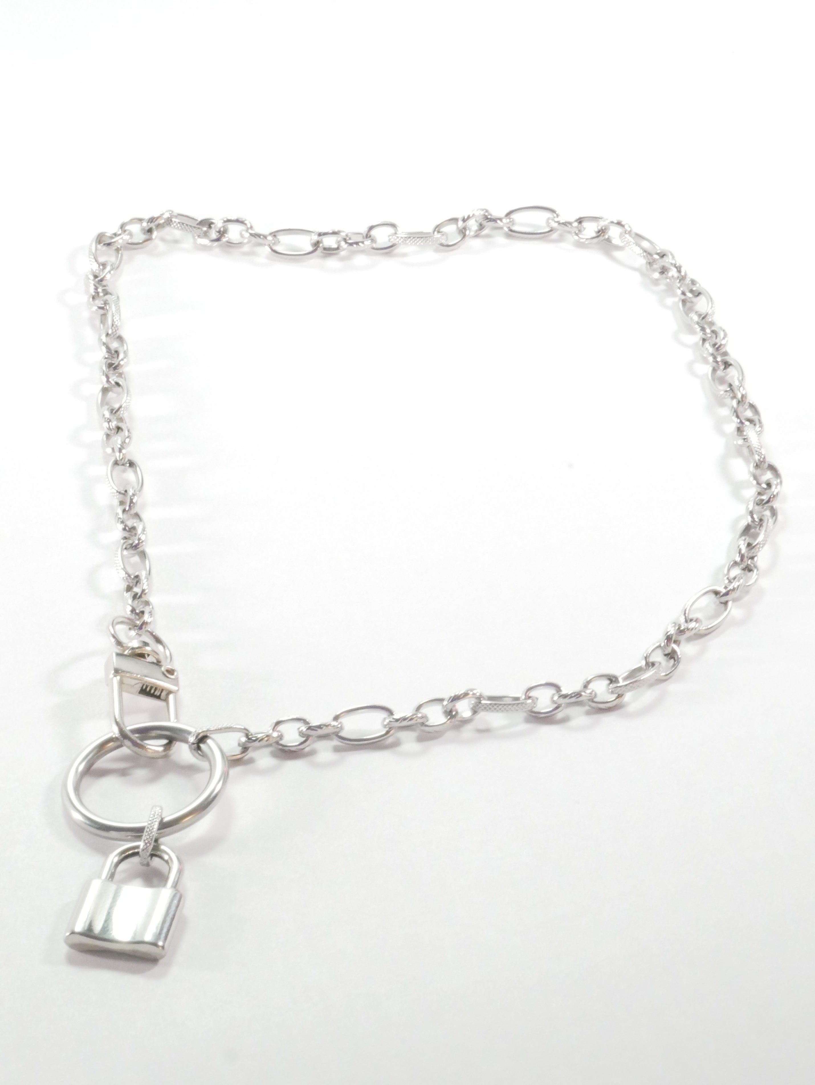Silver chain bracelet with a lock charm on a white background
