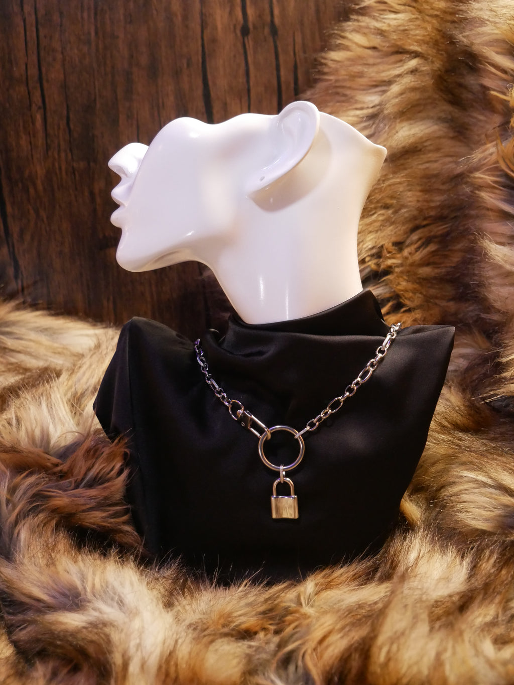 silver chain necklace on a mannequin wearing a black satin top sitting on a brown fur