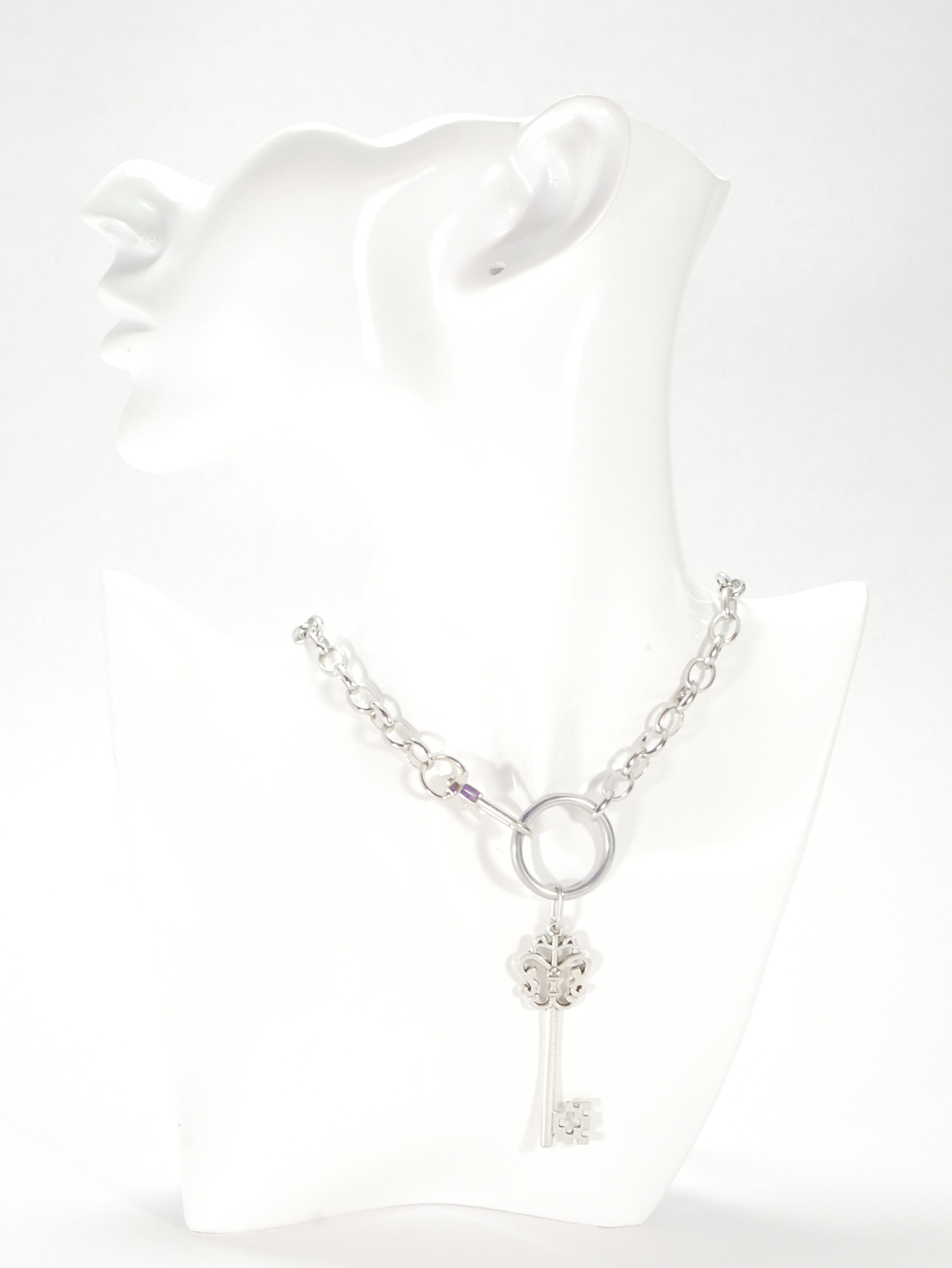 Silver key-shaped pendant on a chain against a white background